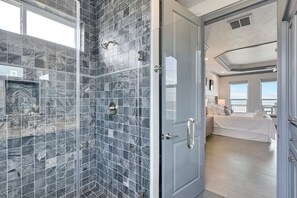 A modern bathroom with a glass-enclosed shower and a walk-in shower area.