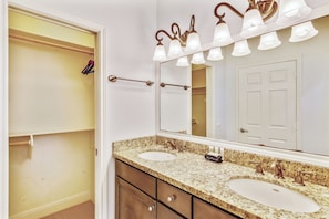 A bathroom with two sinks, a large mirror, and a towel rack.
