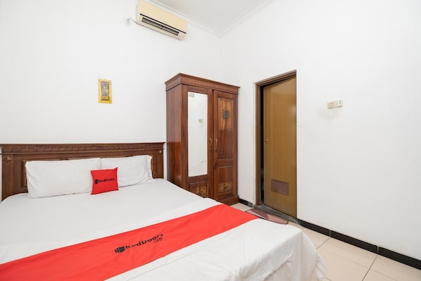A hotel room with a bed, a wardrobe, and a door. - OYO Flagship 90524 Holistay Surabaya New (Surabaya)