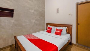 A neatly made bed with a wooden headboard, white and red bedding, and two pillows with the word "OYO" on them. - OYO Flagship 90524 Holistay Surabaya New (Surabaya)
