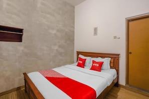 A neatly made bed with a wooden headboard, white and red bedding, and two pillows with the word "OYO" on them. - OYO Flagship 90524 Holistay Surabaya New (Surabaya)
