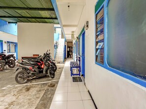 Ein Bahnhof mit Fliesenboden, blauen und weißen Wänden und einem überdachten Bereich mit abgestellten Motorrädern.