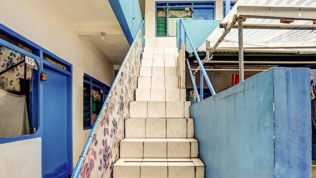 A staircase with blue railings and a floral-patterned wall. - OYO 90523 Homestay Jenggolo (Sidoarjo)