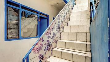 A staircase with blue railings and floral-patterned steps.