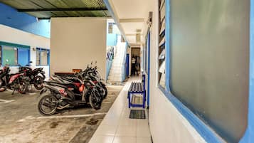 Een overdekte parkeerplaats met meerdere motorfietsen.