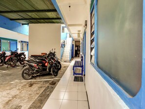 Ein Motorradstellplatz mit überdachtem Bereich und einem gefliesten Weg.