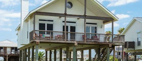 A two-story house with a balcony and a covered porch.