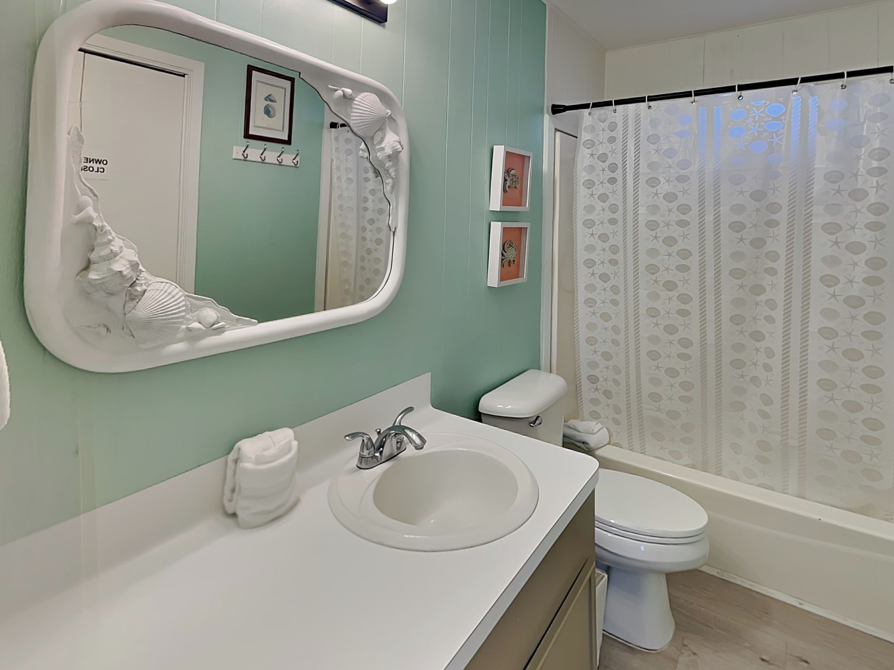 Un baño con lavamanos blanco, inodoro y cortina de ducha con estampado de estrellas.
