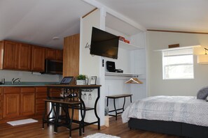 Een compact studio-appartement met kitchenette, een eethoek en een slaapkamer.