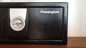 Una caja fuerte negra con mecanismo de cierre circular y el logotipo de SentrySafe.