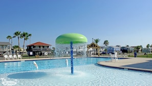 Relax by the pool surrounded by lounge chairs and umbrellas.