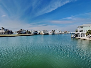 A waterfront property with a marina, featuring a variety of buildings with balconies and waterfront views. - Reel Paradise by Ryson Vacation Rentals (Galveston)
