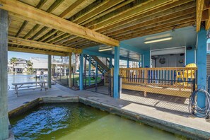 Un espace extérieur abrité doté d’une terrasse en bois, d’une petite piscine et d’un escalier menant à un niveau supérieur.