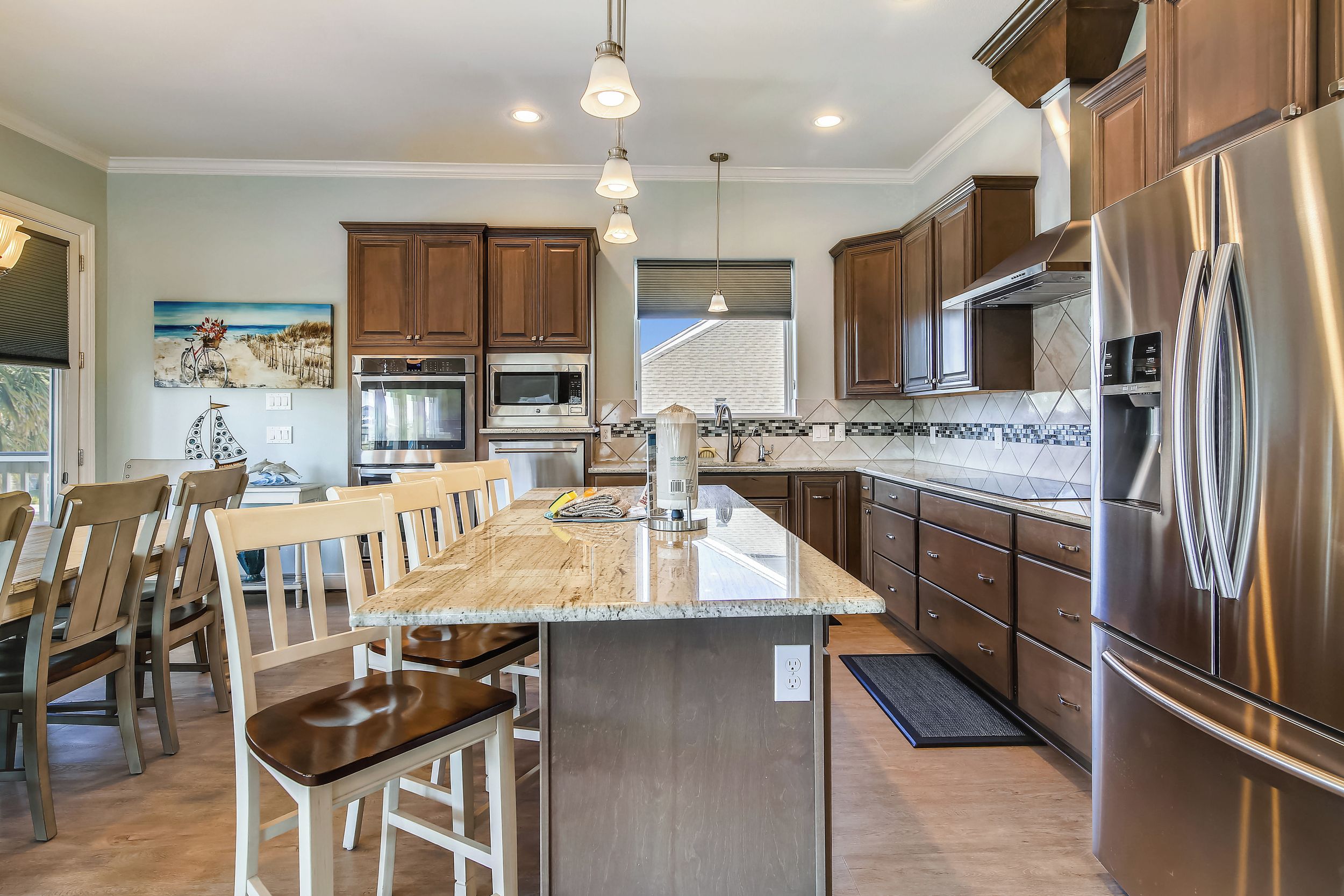 A modern kitchen with a central island, stainless steel appliances, and wooden cabinetry.