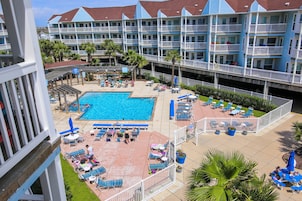 A hotel with a pool area, multiple balconies, and outdoor seating.