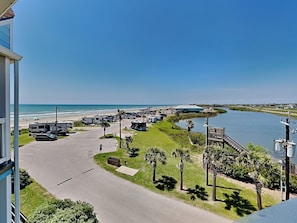 A marina with RVs docked, a beach, and a river. - Beachcomber by Ryson Vacation Rentals (Galveston)