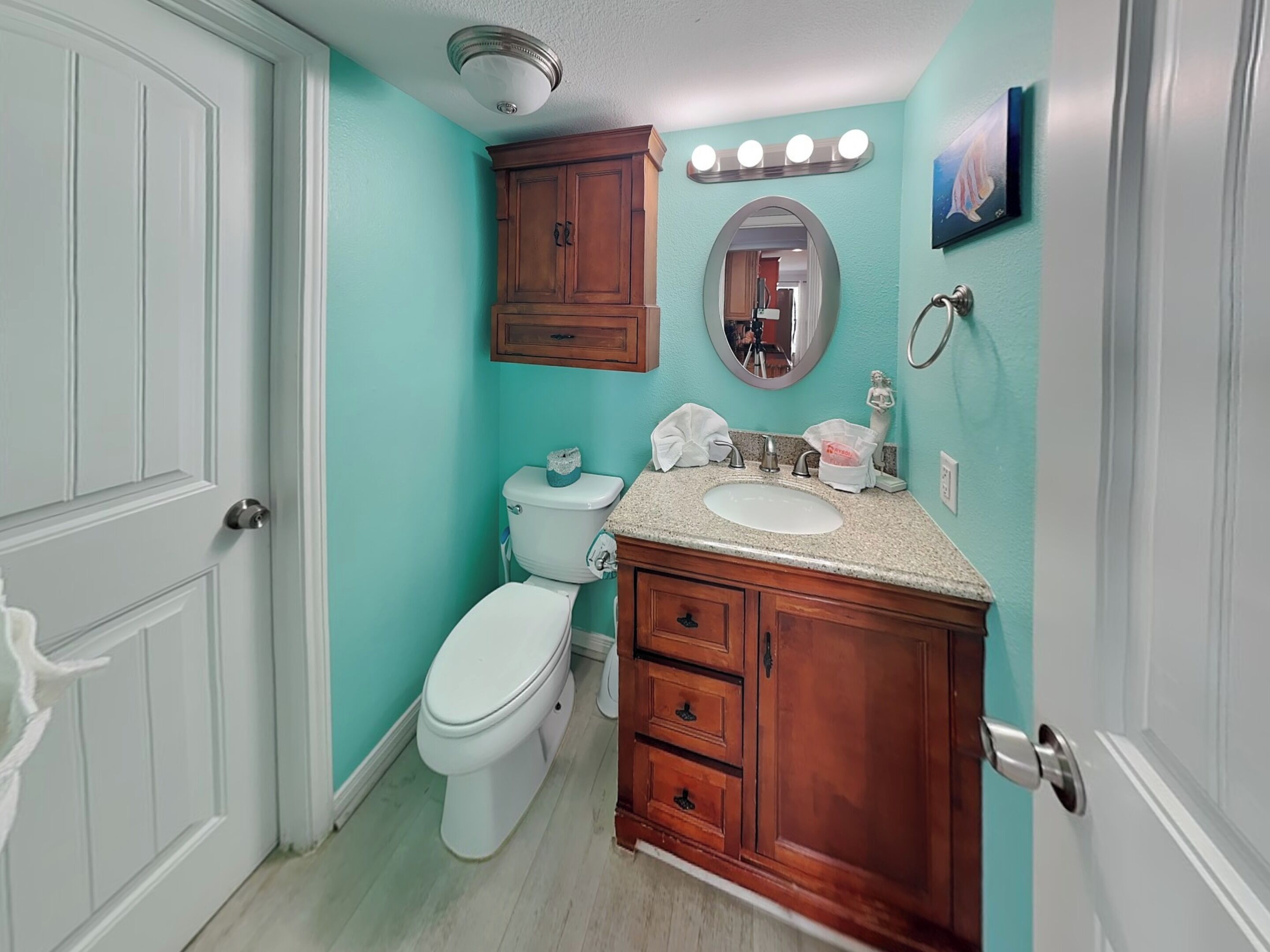 Une salle de bain équipée de toilettes, d’un lavabo, d’un meuble-lavabo et d’un miroir.