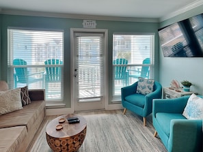 Relax in this inviting living space with a comfortable sofa, armchair, and flat-screen TV.