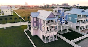 A coastal residential area with multi-story houses featuring balconies and large windows.