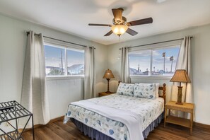 Relax in this serene bedroom with a large bed, ceiling fan, and two bedside tables.
