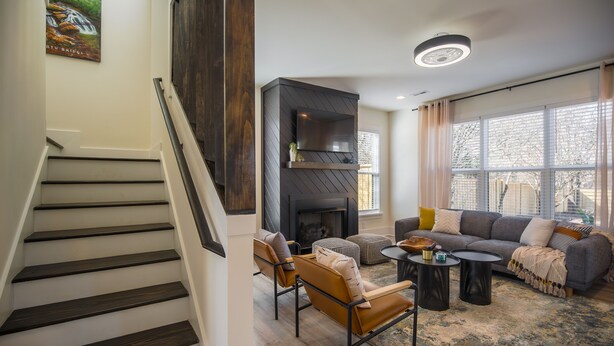A staircase leading to a living area with a fireplace, a sofa set, and a coffee table.