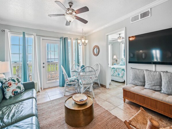 Relax in this open-plan living space with a large flat-screen TV, dining area, and comfortable seating.