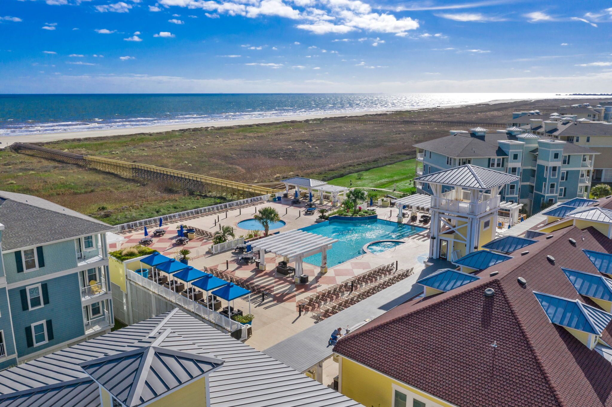 A resort with a large pool, beach access, and multiple buildings with balconies.