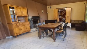 Una cocina amplia con una mesa de comedor de madera y sillas, horno empotrado y un armario grande.