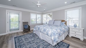 A bedroom with a large bed, a ceiling fan, and a window with blinds. - DEEP WATER Newly Renovated Waterfront Home-Wren's Nest (Edisto Island)