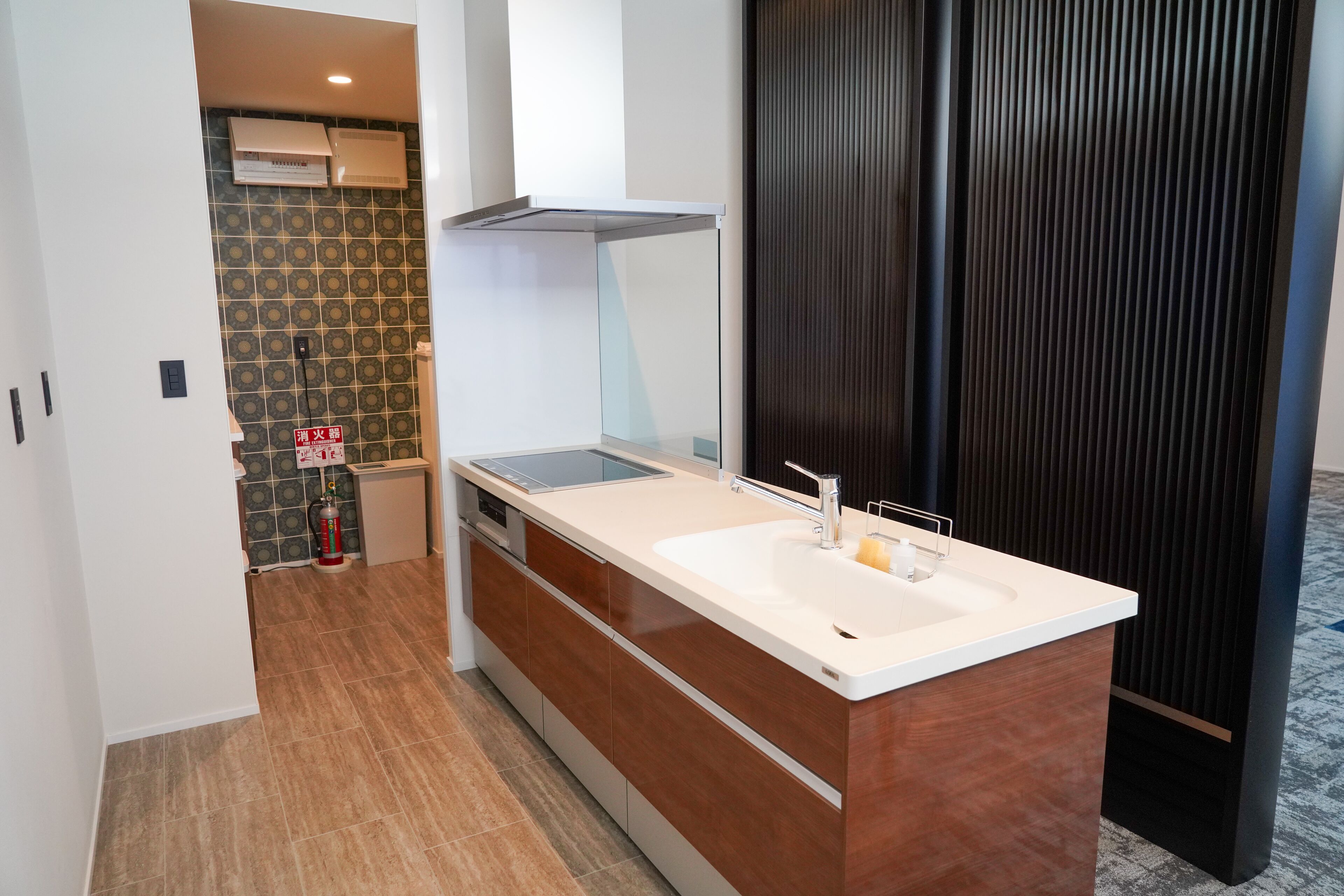 A modern kitchen with a large island, a built-in oven, and a ventilation hood.