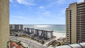 A coastal hotel with multiple buildings, a parking lot, and a beach view. - Grand Panama Resort beautiful condo (Panama City Beach)