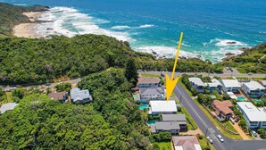 An aerial view of a coastal residential area with houses, a road, and a beach. - Laze @ Lighthouse - modern family home with views and pool (Port Macquarie)