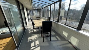 A sunlit corridor with a long table and chairs, large windows, and a view of trees and a road. - 💫🏡6 bedroom/3.5 bath home private acreage parkings (Mission)