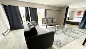 A modern living room with a sectional sofa, a glass coffee table, and a large window with curtains. - 💫🏡6 bedroom/3.5 bath home private acreage parkings (Mission)