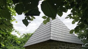 A stone building with a sloped roof and a wooden door.