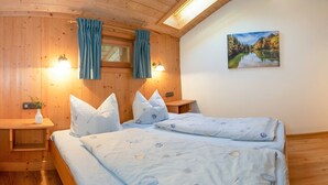 Ein Doppelbett mit einem blumigen Überwurf, einem Holzkopfstück und zwei Nachttischen mit Lampen.