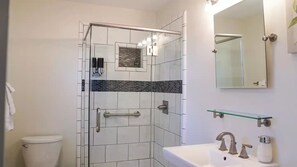 Een bad/douchecombinatie, een haardroger, handdoeken, zeep