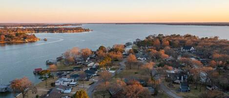 An aerial view of a residential area with houses, a dock, and a body of water.