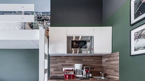 A modern kitchen with a built-in microwave, a coffee maker, and a sink. - Revelton Studios Prague (Prague)