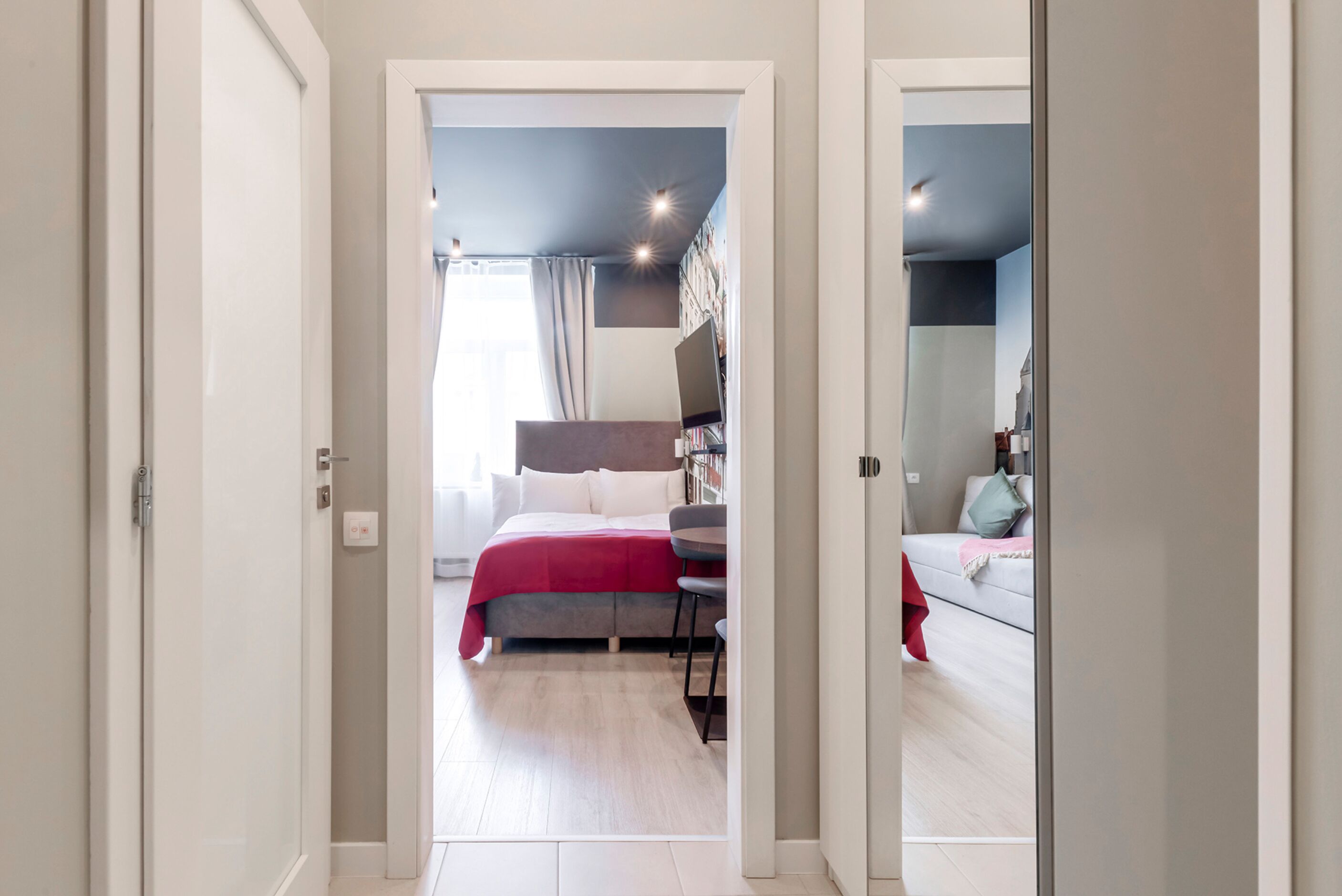 A modern bedroom with a bed, bedside table, and a desk with a chair.