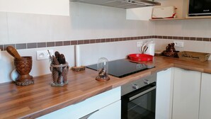 Una cocina moderna con encimera de madera, horno empotrado y microondas.