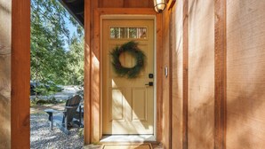 A wooden cabin entrance with a door, a welcome mat, and a wreath. - Guest Favorite Mt. Hood Cabin - Private Hot Tub - Sandy River (Rhododendron)