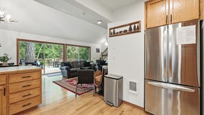A modern kitchen with wooden cabinets, a stainless steel refrigerator, and a compact dishwasher. - Guest Favorite Mt. Hood Cabin - Private Hot Tub - Sandy River (Rhododendron)