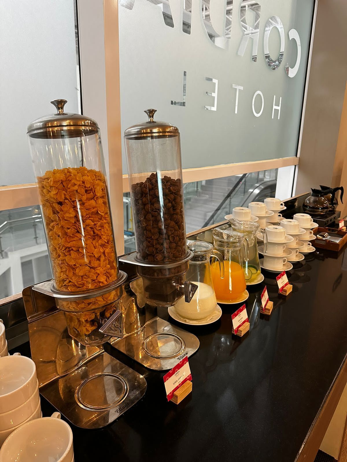 Ein Frühstücksbuffet mit Müsli, Kaffee und Orangensaft.