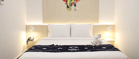 A hotel room with a large bed, white bedding, two bedside lamps, a telephone, and a decorative wall hanging.