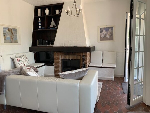 A living room with a fireplace, a sofa, a coffee table, and a bookshelf. - Annette - Albir, Albir, Costa Blanca (Albir)