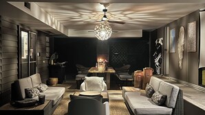 Et moderne, veloplyst interiør med en loftsvifte, en mønstret lampe og et hyggeligt opholdsområde med sofaer og et sofabord.