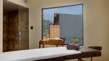 Relax in a serene space with a massage table, side table, and stunning city view.