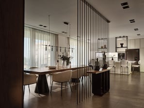 A modern kitchen with a dining area, featuring a wooden table, chairs, and a kitchen island.