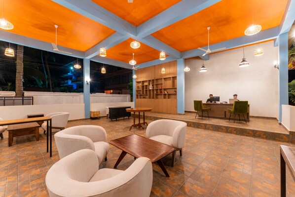 A spacious lobby with a reception desk, seating area, and a view of the outside.